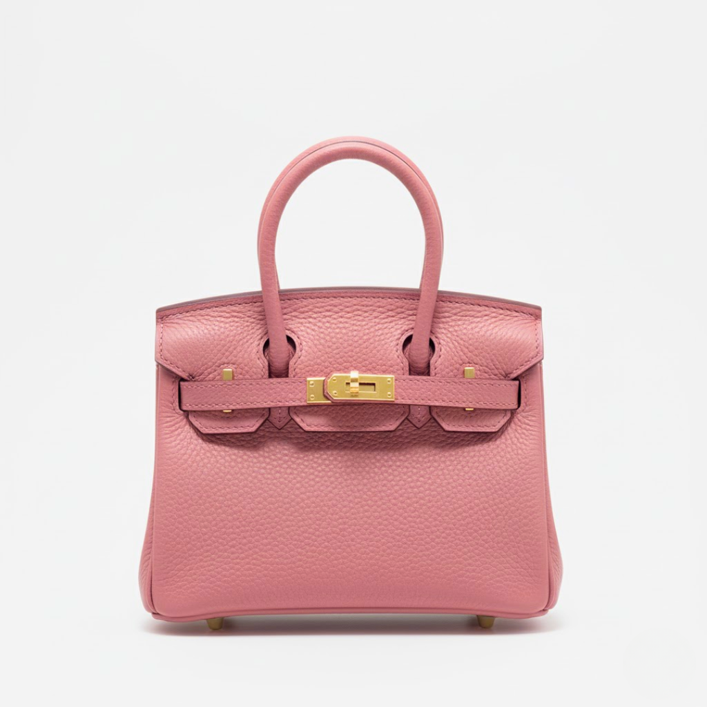 Pink handbag with gold hardware on a light gray background