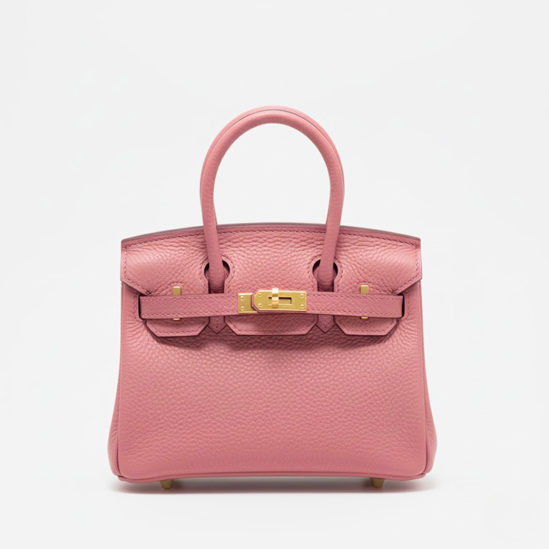 Pink handbag with gold hardware on a light gray background