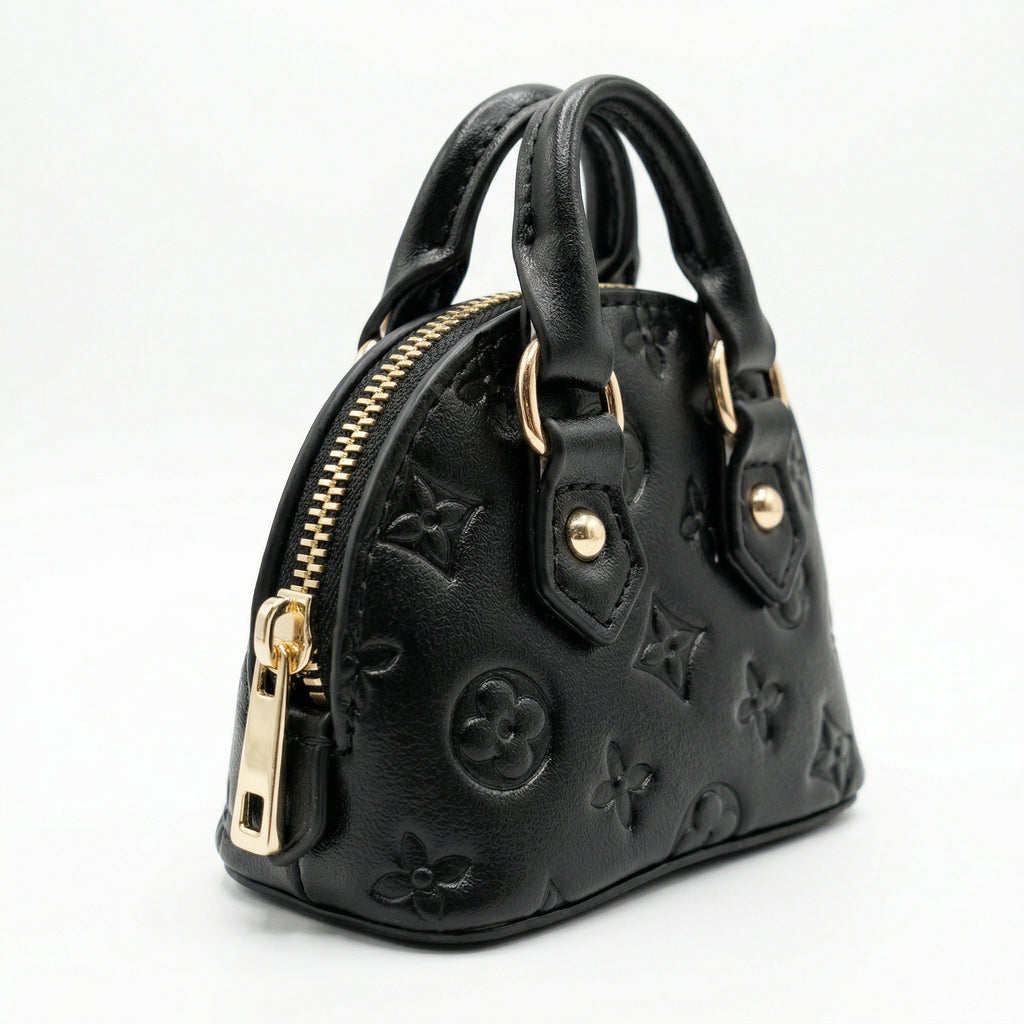 Black handbag with gold zippers on a white background